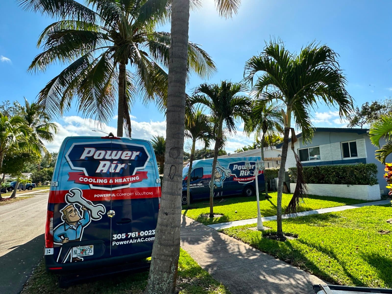Power Air Cooling & Heating service vans in a South Florida neighborhood